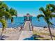 Picturesque view of a waterfront gazebo at the end of a pier framed by palm trees on the beach at 8 Desoto E St, Bradenton, FL 34208