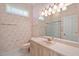 Well lit bathroom with floral wallpaper, vanity, and pink fixtures at 8 Dominica Dr, Englewood, FL 34223