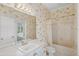 Bright bathroom features white vanity, shower-tub, and floral patterned wallpaper at 8 Dominica Dr, Englewood, FL 34223
