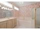 Bathroom features a double vanity, bathtub and shower with bright light fixtures at 8 Dominica Dr, Englewood, FL 34223