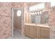 Bathroom featuring pink floral wallpaper, vanity, and large mirror with decorative lighting at 8 Dominica Dr, Englewood, FL 34223