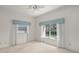 Bright bedroom featuring large windows, neutral carpet, and blue accents, perfect for a calm retreat at 8 Dominica Dr, Englewood, FL 34223