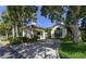 Elegant clubhouse entrance featuring porte cochere, lush landscaping, and architectural details at 8 Dominica Dr, Englewood, FL 34223