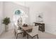 Elegant dining room with a modern chandelier, a large window, and stylish furniture at 8 Dominica Dr, Englewood, FL 34223