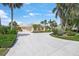 Exterior shot of a house showing a large, neutral colored three-car garage and extended driveway at 8 Dominica Dr, Englewood, FL 34223
