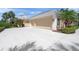 View of a home's three-car garage, and neutral-colored exterior at 8 Dominica Dr, Englewood, FL 34223