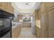 Bright kitchen featuring wood cabinets, neutral tile flooring, and modern appliances at 8 Dominica Dr, Englewood, FL 34223
