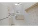 Bright laundry room features white appliances, cabinets, and neutral floral wallpaper at 8 Dominica Dr, Englewood, FL 34223