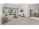 Staged living room with white furniture, artwork, and glass coffee table, opening to the pool at 8 Dominica Dr, Englewood, FL 34223