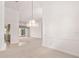 Spacious living room with white walls, light carpet and an ornate chandelier hanging above at 8 Dominica Dr, Englewood, FL 34223