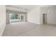 Spacious living room featuring tile and carpet flooring leading to screened-in pool and patio area at 8 Dominica Dr, Englewood, FL 34223