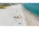 Gorgeous aerial view of the beach, and ocean, with a lifeguard tower and people enjoying the sun at 924 Indian Beach Dr, Sarasota, FL 34234