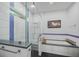 Contemporary bathroom featuring a walk-in shower with glass surround, and a separate bathtub with tiled accents at 924 Indian Beach Dr, Sarasota, FL 34234
