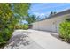 Spacious driveway leads to a three-car garage, surrounded by lush greenery at 924 Indian Beach Dr, Sarasota, FL 34234