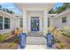 Covered front entrance with blue double doors flanked by matching blue potted plants at 924 Indian Beach Dr, Sarasota, FL 34234