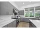 Gorgeous kitchen features stone countertops, stainless steel appliances, and grey cabinets at 924 Indian Beach Dr, Sarasota, FL 34234