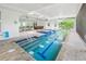 Indoor swimming pool with ample lighting, an adjacent jacuzzi, and inviting steps at 924 Indian Beach Dr, Sarasota, FL 34234