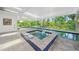 Stunning indoor pool featuring a jacuzzi and lush outdoor views at 924 Indian Beach Dr, Sarasota, FL 34234