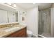 Bathroom featuring granite vanity countertop, and walk-in tiled shower with glass door at 101 S Gulfstream Ave # 6C, Sarasota, FL 34236