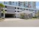 The condo building features an attached covered parking garage and a welcoming entrance with lush landscaping at 101 S Gulfstream Ave # 6C, Sarasota, FL 34236