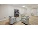 A well-lit resident reading area with comfortable chairs and decorative shelving with books at 101 S Gulfstream Ave # 6C, Sarasota, FL 34236