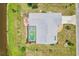 Overhead view of home with pool, lush landscaping, and a well-kept lawn, next to a pond at 104 Hourglass Dr, Venice, FL 34293
