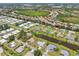 Expansive aerial view showcases a residential community with water views and well-maintained landscaping at 104 Hourglass Dr, Venice, FL 34293