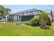 Lush backyard with an enclosed screened-in pool, vibrant flowers, and mature landscaping at 104 Hourglass Dr, Venice, FL 34293