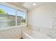 Bathroom featuring a bathtub with a window view and patterned wallpaper at 104 Hourglass Dr, Venice, FL 34293