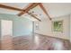 Bright room featuring wood floors, two windows and exposed wood beams on the ceiling at 104 Hourglass Dr, Venice, FL 34293