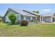 Well-kept house featuring neat landscaping, flower beds, and a walkway, complemented by a clean, gray and white exterior at 104 Hourglass Dr, Venice, FL 34293