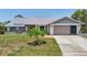 Charming single-story home with a well-manicured lawn, attached garage, and inviting front entrance at 104 Hourglass Dr, Venice, FL 34293