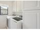 This laundry room has modern appliances and cabinets for storage at 104 Hourglass Dr, Venice, FL 34293