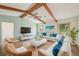 Bright living room features wood beams, ceiling fan, and two couches facing a modern entertainment center at 104 Hourglass Dr, Venice, FL 34293