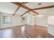 Spacious open living area with hardwood floors, ceiling fan, and exposed wooden beams at 104 Hourglass Dr, Venice, FL 34293