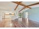 Open living space featuring wood floors, wood beams on ceiling, and a view into the kitchen and outdoor patio at 104 Hourglass Dr, Venice, FL 34293
