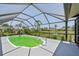 Enclosed screened-in pool with scenic views of lush greenery, a serene lake, and clear blue skies at 104 Hourglass Dr, Venice, FL 34293