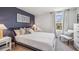 Comfortable bedroom featuring neutral bedding, stylish lamps, and a large window for natural light and scenic outdoors views at 10721 Hidden Banks Gln, Parrish, FL 34219