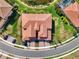 Stunning aerial view of a home featuring a red tile roof, a well manicured lawn, and a circular driveway at 10820 Tarflower Dr # 202, Venice, FL 34293