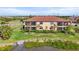 Charming exterior view highlighting the inviting facade and serene water view from a screened patio at 10820 Tarflower Dr # 202, Venice, FL 34293