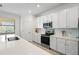 Well-lit kitchen features sleek countertops, stainless steel appliances, and modern white cabinets at 10820 Tarflower Dr # 202, Venice, FL 34293