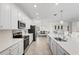 Modern kitchen with stainless steel appliances, white cabinets, and an open layout to the dining area at 10820 Tarflower Dr # 202, Venice, FL 34293