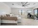 Main bedroom with a large window, ceiling fan, and balcony access, adjacent to a computer desk at 10820 Tarflower Dr # 202, Venice, FL 34293