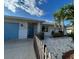 Charming single-story home with a blue garage door, tidy landscaping, and decorative white stone at 1204 Sunrise Rd, Venice, FL 34293