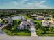 Gorgeous aerial view of a single-Gathering home with lush landscaping, a pond, and a tile roof at 13115 Harriers Pl, Bradenton, FL 34212