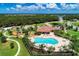 Aerial view of community clubhouse with a resort-style pool, playground, and green space at 13115 Harriers Pl, Bradenton, FL 34212