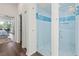 Elegant bathroom features a modern glass-enclosed shower with blue tiled accents and a walk-out to the yard at 13115 Harriers Pl, Bradenton, FL 34212