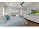 Bright bedroom with tray ceilings, a ceiling fan, and sliding glass doors to the lanai at 13115 Harriers Pl, Bradenton, FL 34212
