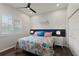 Bright bedroom features a colorful floral bed set, shuttered windows and a ceiling fan at 13115 Harriers Pl, Bradenton, FL 34212