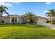 Well-manicured lawn and landscaping surround this single-story home with a tile roof and neutral exterior at 13115 Harriers Pl, Bradenton, FL 34212